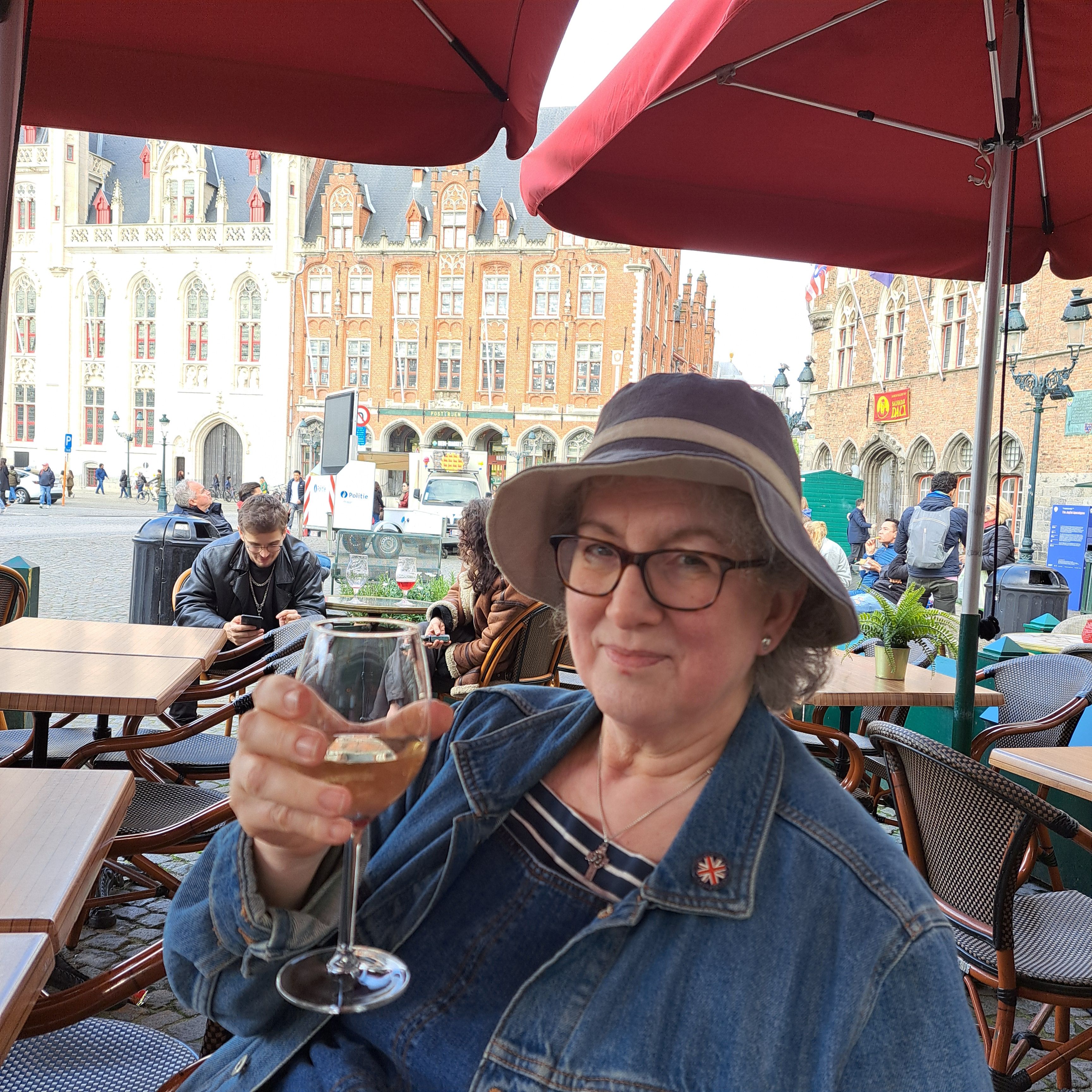 Photo of Debbie raising a glass of wine in Bruges