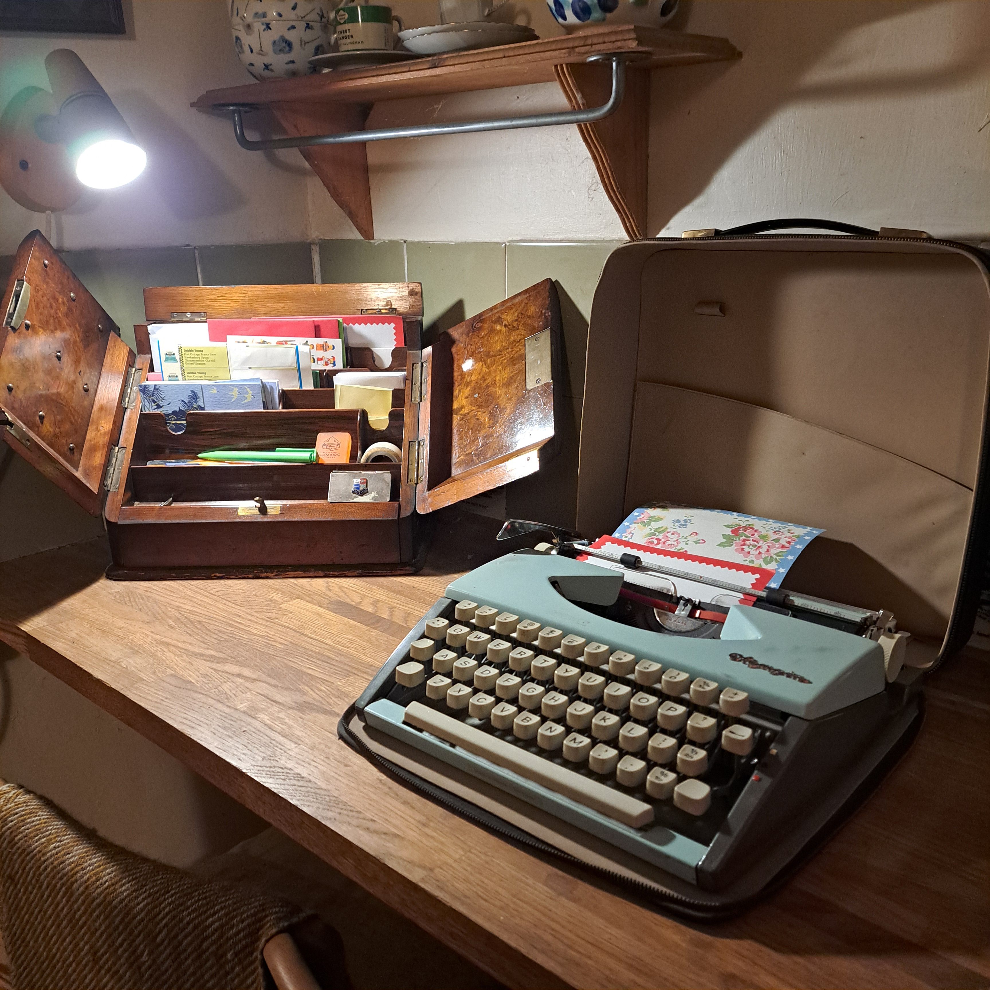 manual typewriter on desk with stationery box beside it